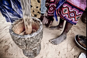 Un grupo de mujeres moliendo cereales en un mortero en el campo de refugiados sudaneses de Djabal. (c) Pablo Tosco / Intermón Oxfam